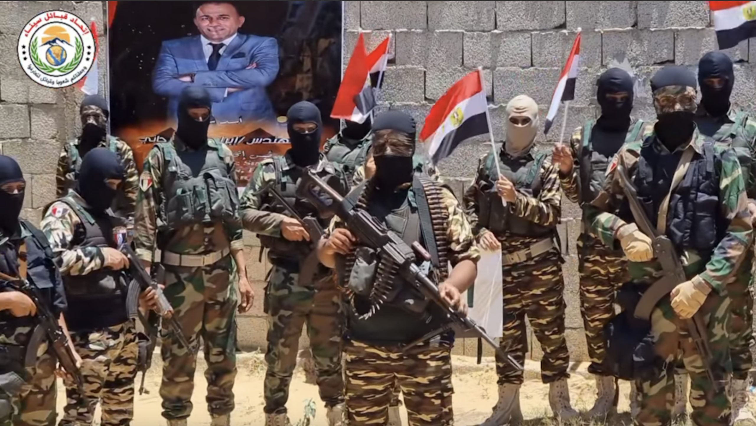 Un fotograma de un video publicado por los Haytham Knights, la fuerza de élite de la Unión de Tribus del Sinaí, el año pasado. Se ve una fotografía de Ibrahim al-Arjani al fondo.